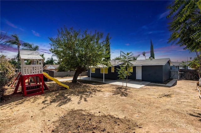 view of yard with a patio, a playground, and fence