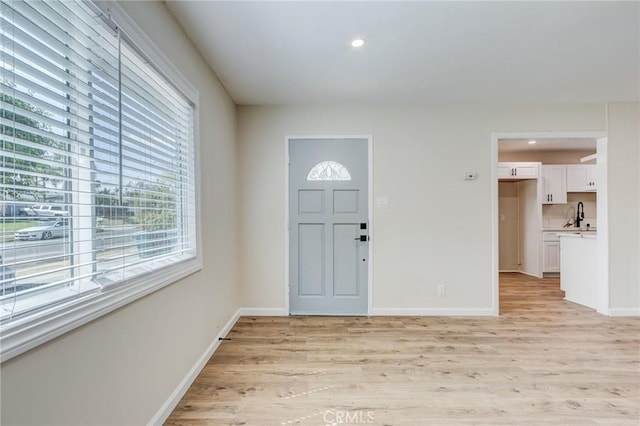 entryway with recessed lighting, baseboards, and light wood-style floors