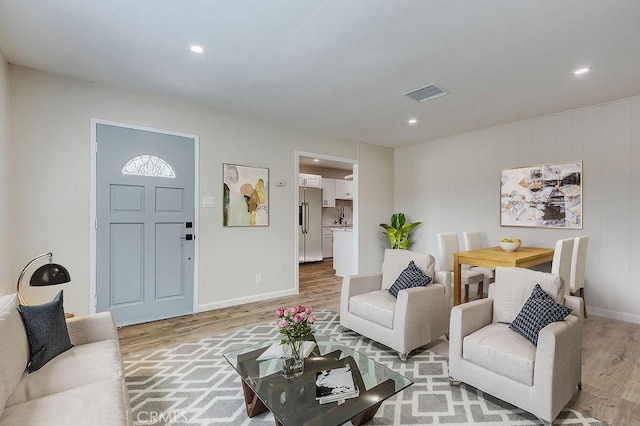 living room featuring recessed lighting, light wood-style floors, visible vents, and baseboards