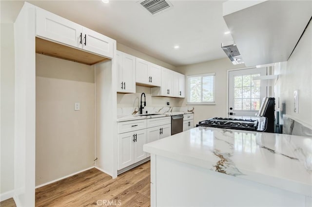 kitchen featuring sink, light hardwood / wood-style flooring, light stone counters, white cabinets, and stainless steel dishwasher