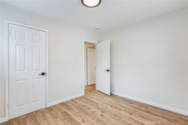 unfurnished bedroom featuring light wood-style flooring and baseboards