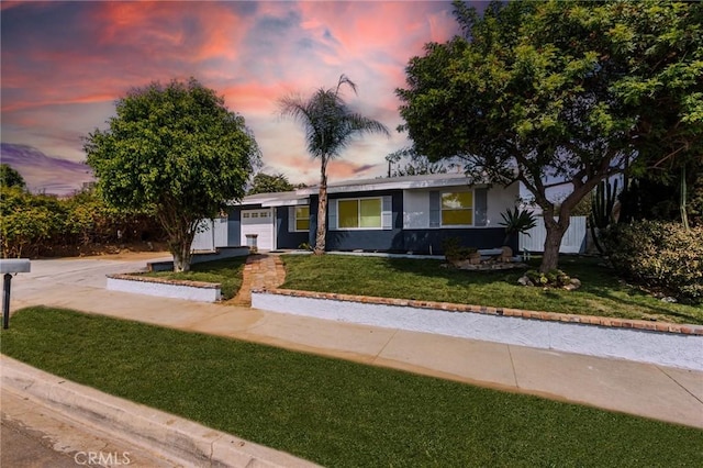 single story home featuring a lawn and a garage