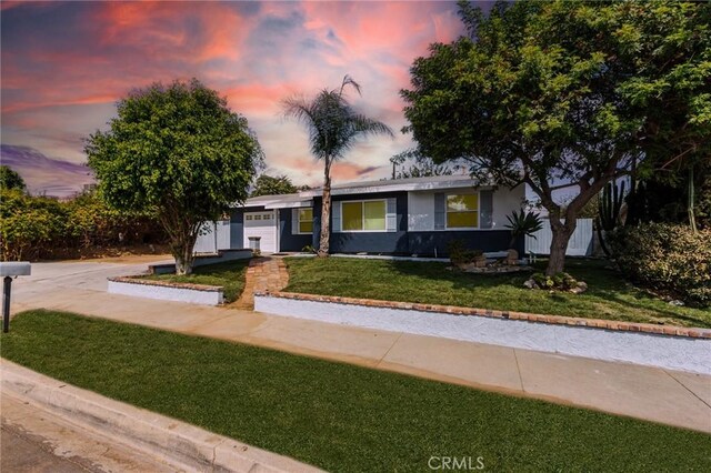 single story home with a yard and a garage