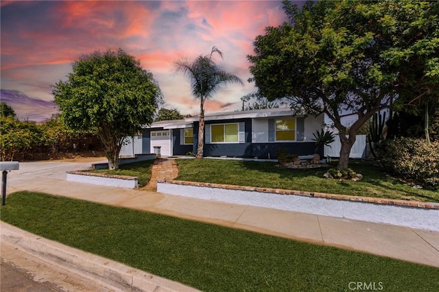 ranch-style home with a garage, stucco siding, and a front yard