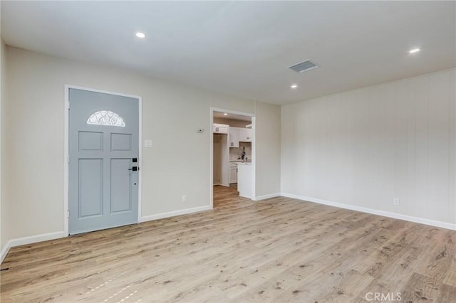 foyer with visible vents, baseboards, and light wood-style flooring