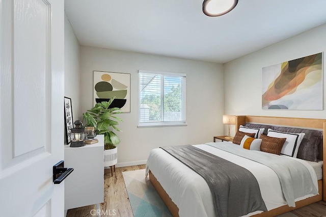 bedroom with wood finished floors and baseboards