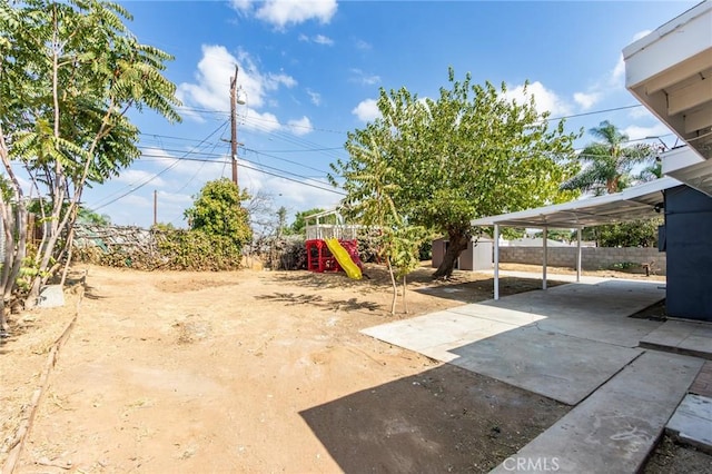 view of yard with a storage unit, an outbuilding, a fenced backyard, and a playground