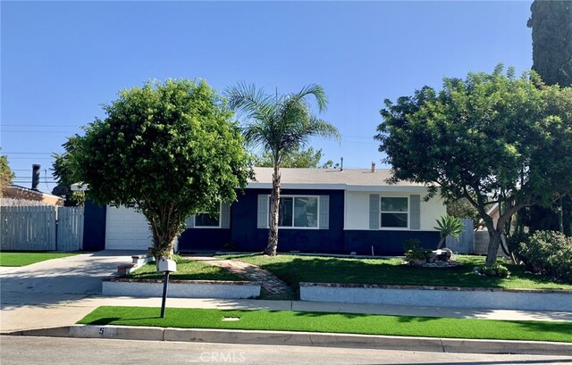 ranch-style house featuring a garage and a front lawn