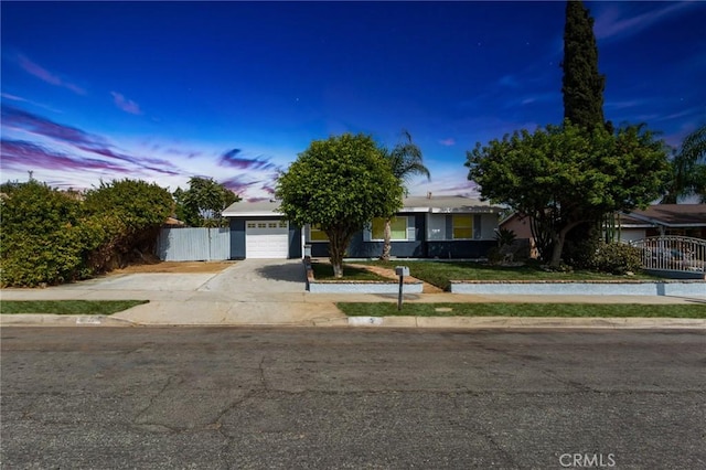 obstructed view of property with a gate, concrete driveway, an attached garage, and fence