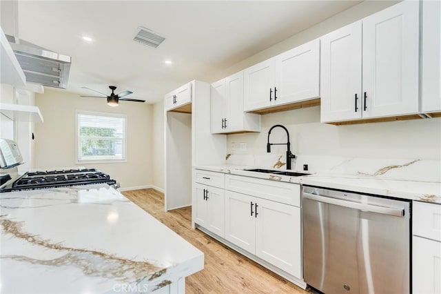 kitchen featuring a sink, visible vents, dishwasher, and white cabinets