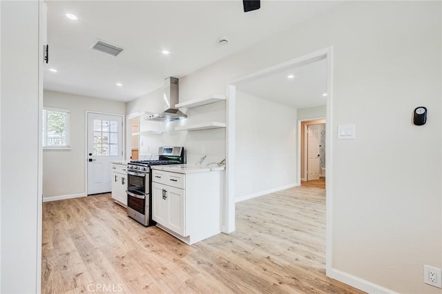 kitchen featuring visible vents, wall chimney range hood, double oven range, white cabinets, and open shelves