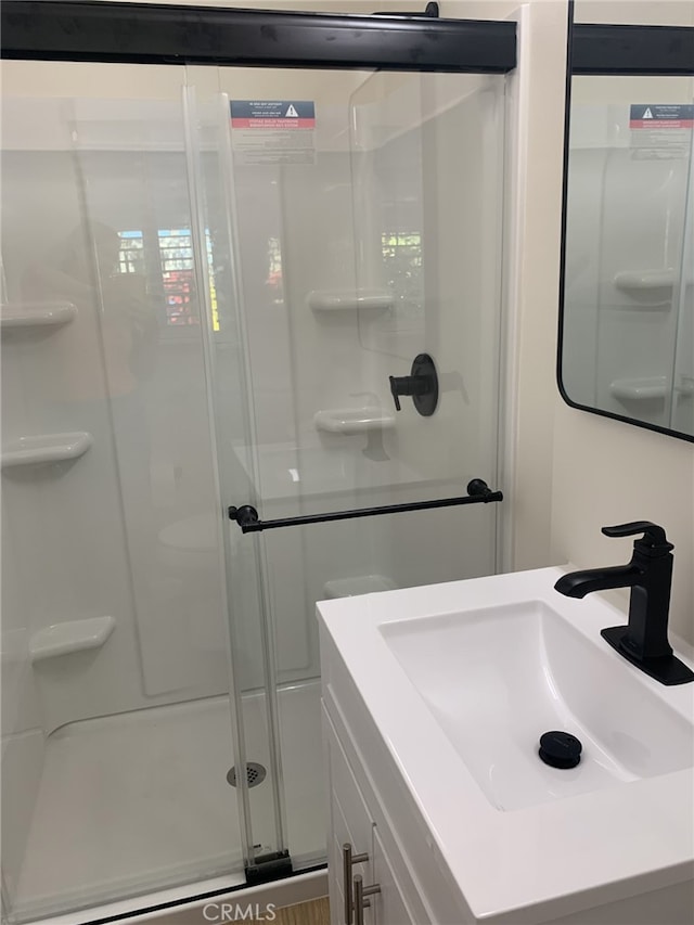 bathroom featuring sink and a shower with shower door