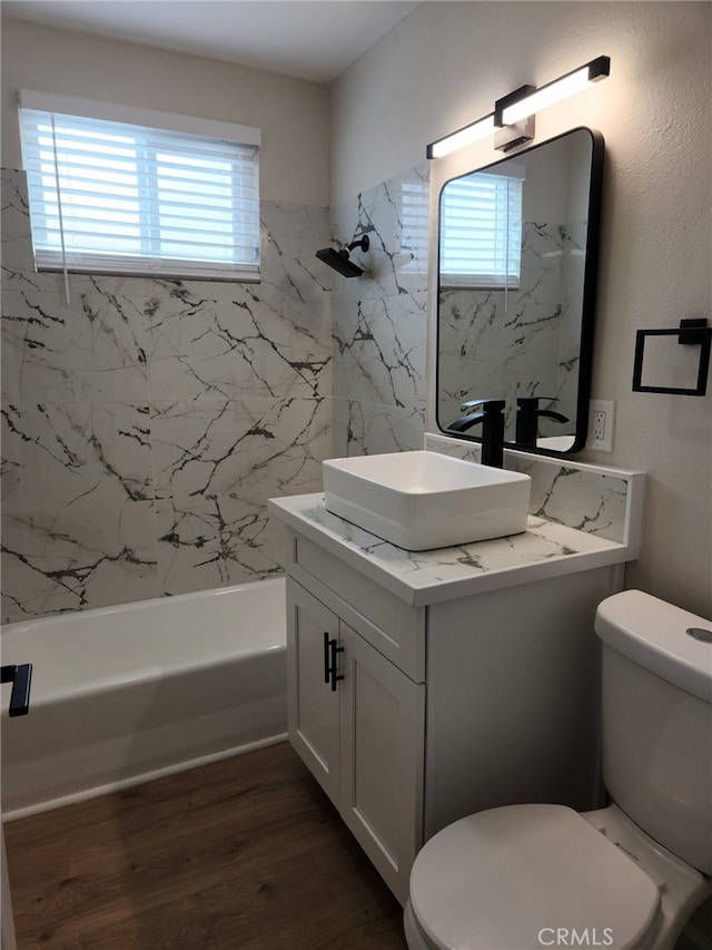 full bathroom featuring toilet, vanity, bathtub / shower combination, and wood finished floors