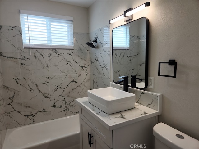 bathroom with toilet, bathtub / shower combination, vanity, and a textured wall