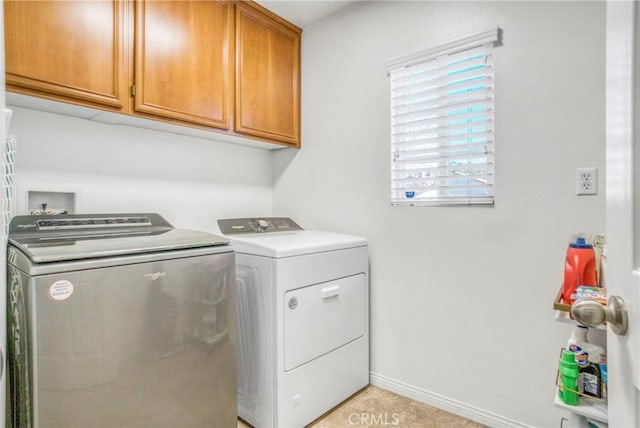 washroom featuring cabinets, separate washer and dryer, and light tile patterned floors