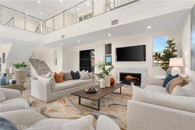 living room with a fireplace and a towering ceiling