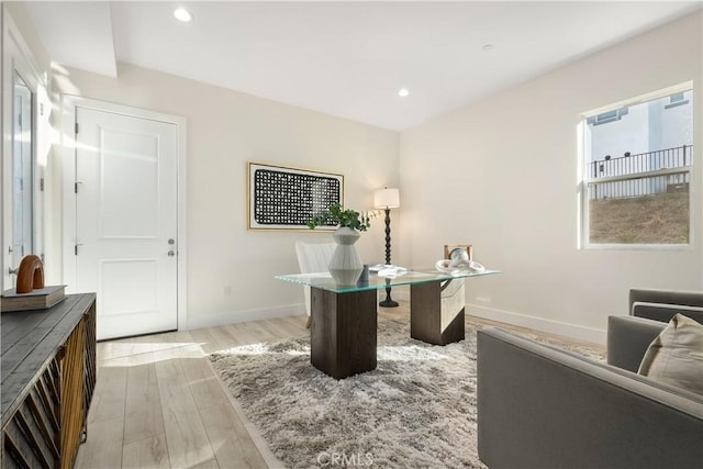 home office with light hardwood / wood-style flooring