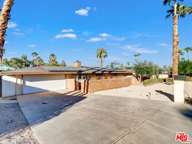 view of front of property featuring a garage and solar panels