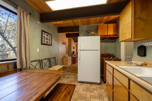 kitchen with high end stainless steel range, wood ceiling, white refrigerator, sink, and beam ceiling