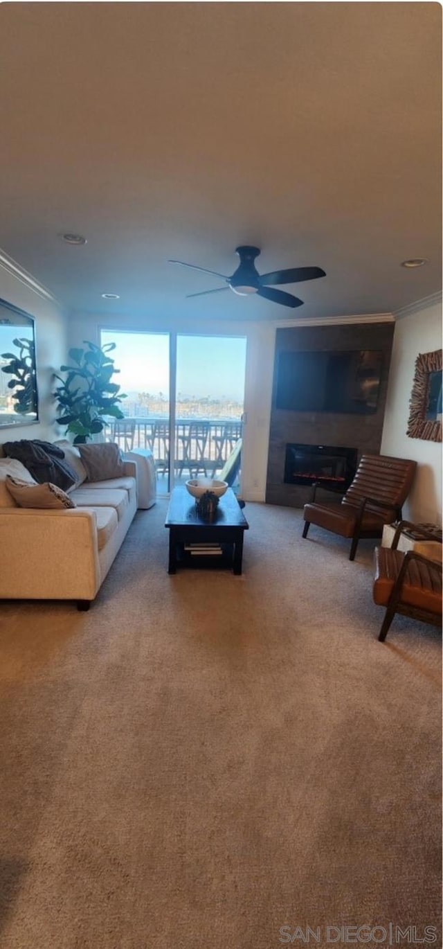 carpeted living room featuring ceiling fan and crown molding