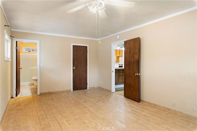 unfurnished bedroom featuring ceiling fan, light hardwood / wood-style floors, ensuite bathroom, and crown molding