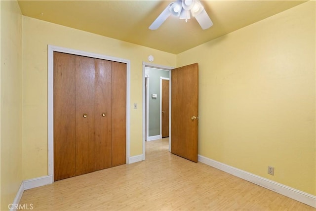 unfurnished bedroom with a closet, light hardwood / wood-style floors, and ceiling fan