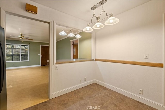 unfurnished dining area with ceiling fan and crown molding