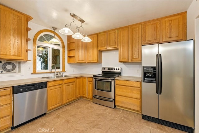 kitchen featuring appliances with stainless steel finishes, sink, and pendant lighting