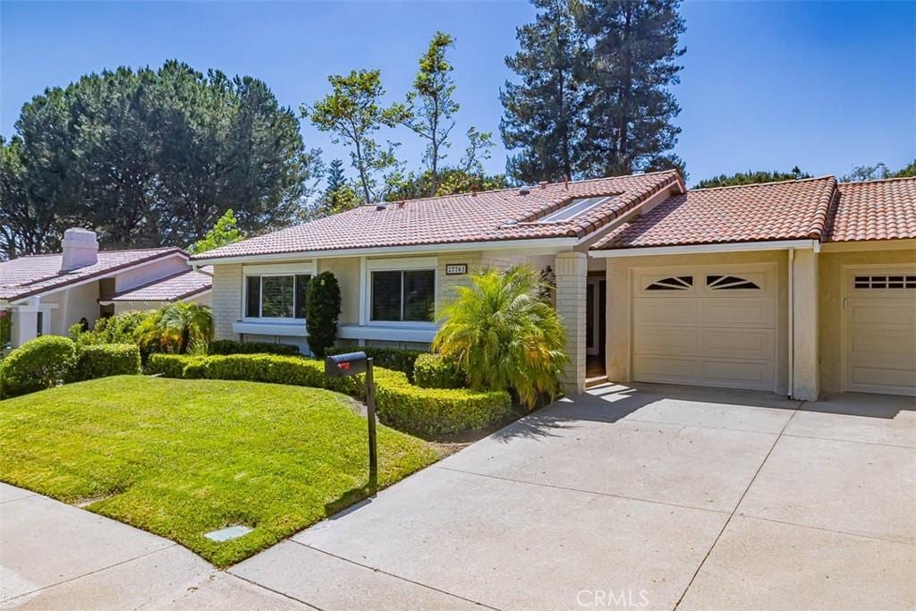 ranch-style house featuring a front yard and a garage