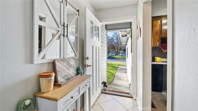 doorway featuring a textured ceiling and light tile patterned flooring