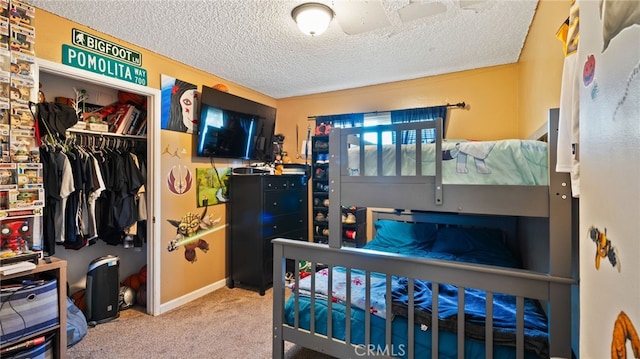 bedroom with a closet, a textured ceiling, and carpet flooring