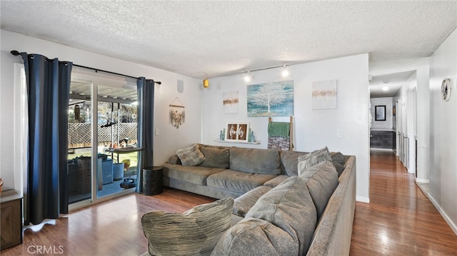 living room featuring rail lighting, a textured ceiling, and hardwood / wood-style floors