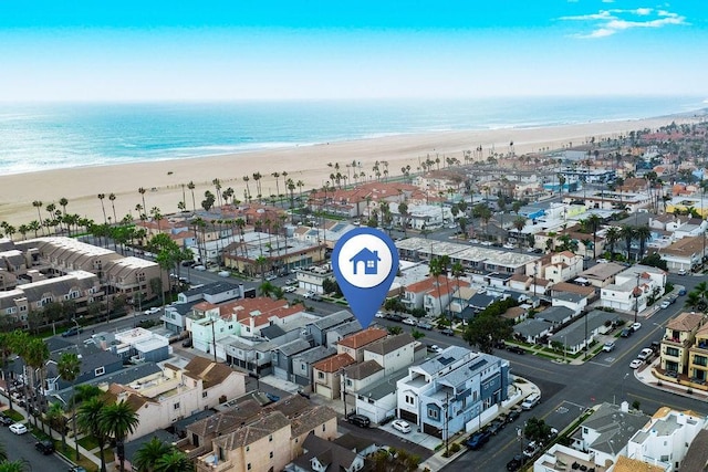 drone / aerial view featuring a water view and a beach view