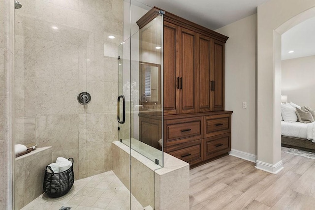 bathroom featuring wood-type flooring and an enclosed shower