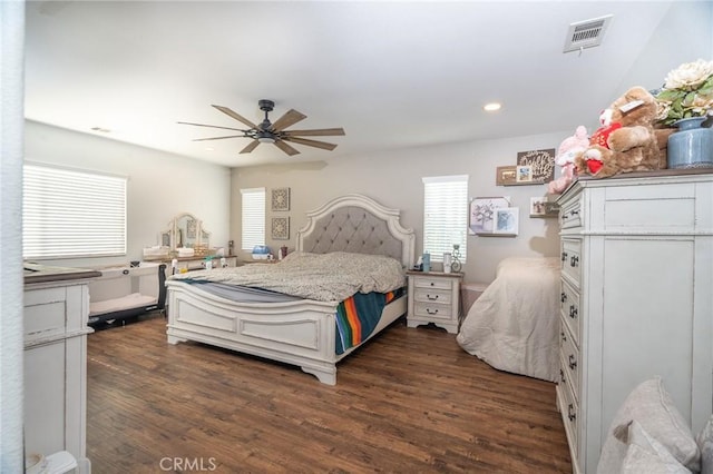 bedroom featuring ceiling fan, dark hardwood / wood-style floors, and multiple windows