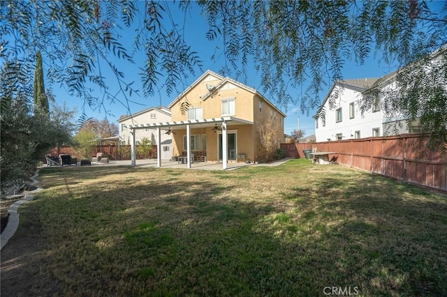 back of house with a pergola, a patio area, and a lawn