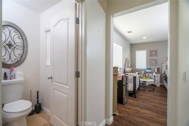 bathroom featuring hardwood / wood-style flooring and toilet