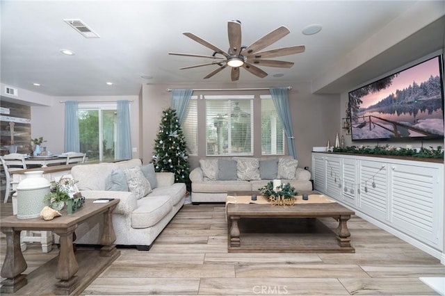 living room with ceiling fan and light wood-type flooring