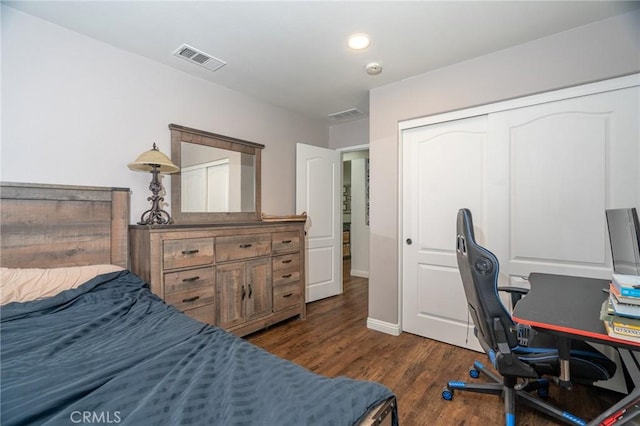 bedroom with dark hardwood / wood-style flooring and a closet