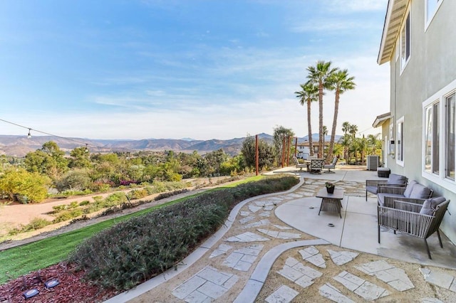 view of patio featuring central AC, outdoor lounge area, and a mountain view