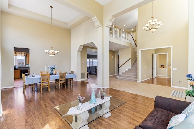 living room featuring an inviting chandelier, tile patterned floors, and a towering ceiling