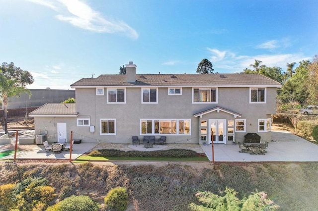 rear view of property with french doors and a patio