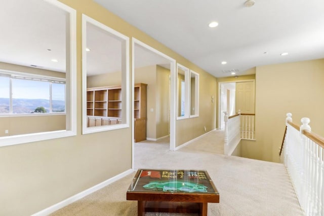 hall with light colored carpet