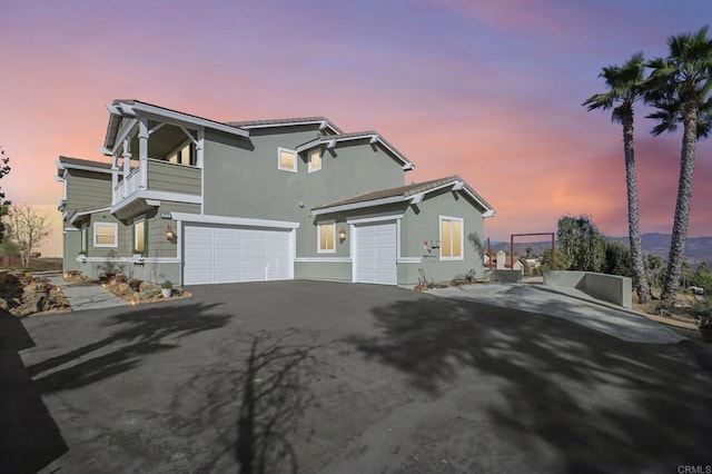 view of front facade featuring a garage and a balcony