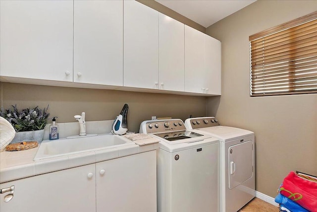 laundry room featuring cabinets, washer and dryer, and sink