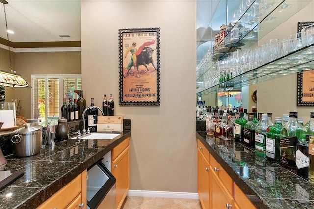 bar featuring crown molding, sink, hanging light fixtures, and light tile patterned floors