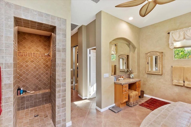 bathroom with tile patterned flooring, vanity, tiled shower, and ceiling fan