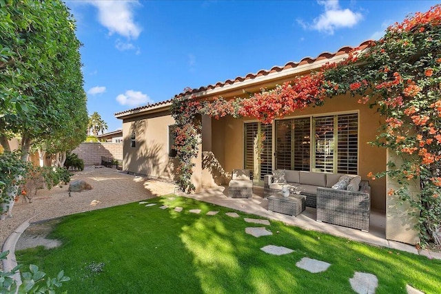 back of house featuring an outdoor living space, a patio area, and a lawn