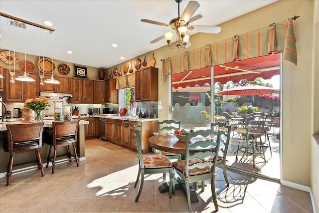 kitchen featuring pendant lighting, ceiling fan, dishwasher, tasteful backsplash, and light tile patterned flooring