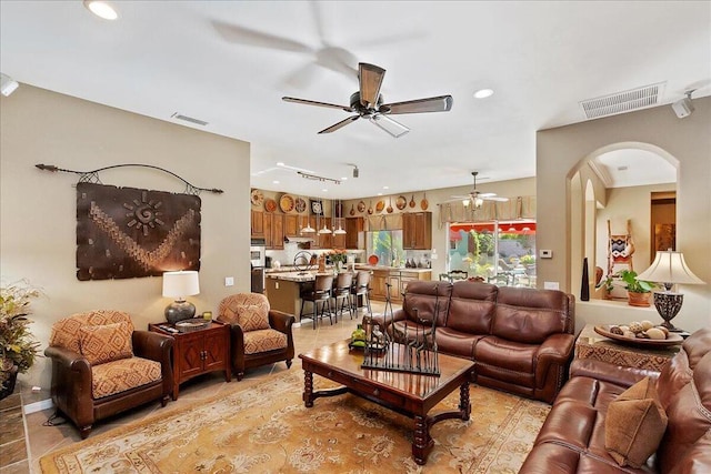 tiled living room with ceiling fan